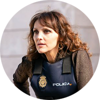 portrait of a woman with curly hair wearing a police vest.