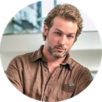 portrait of a blonde man wearing a brown shirt.